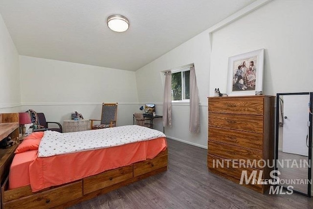 bedroom with vaulted ceiling and wood finished floors
