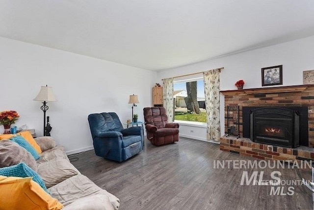 living room featuring baseboards, wood finished floors, and a fireplace