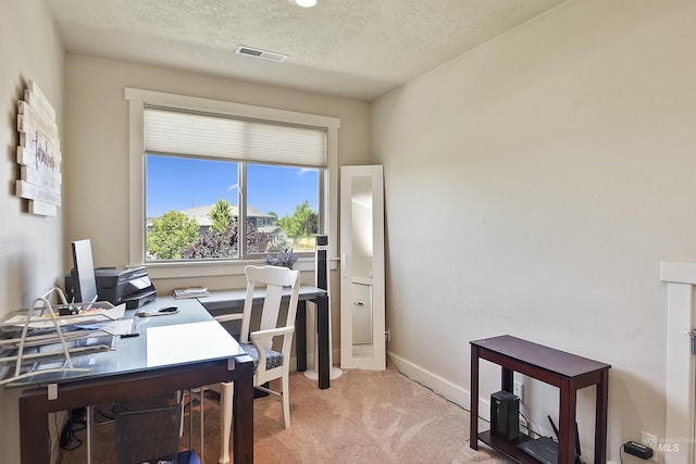 carpeted home office with a textured ceiling