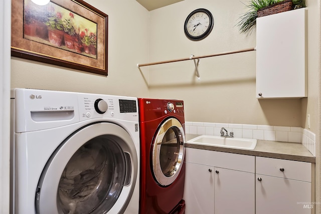 washroom featuring sink, cabinets, and washing machine and clothes dryer