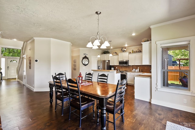 dining room featuring a notable chandelier, ornamental molding, dark hardwood / wood-style floors, and a textured ceiling