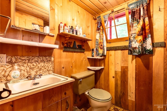 bathroom featuring wooden ceiling, vanity, toilet, and wood walls