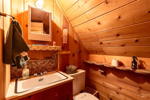 bathroom featuring vanity, vaulted ceiling, wood walls, wood ceiling, and toilet