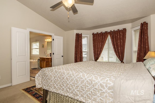 bedroom featuring lofted ceiling, a textured ceiling, ceiling fan, ensuite bathroom, and carpet floors