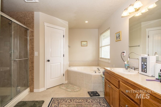 full bath with a textured ceiling, vanity, a shower stall, a bath, and tile patterned floors