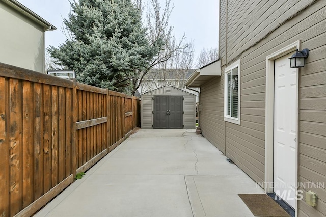 view of patio / terrace featuring a shed, an outdoor structure, and fence