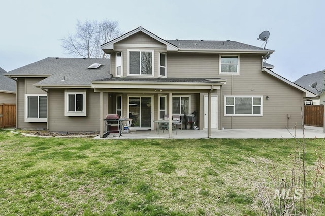 back of property with a patio area, fence, and a lawn