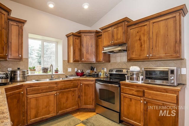 kitchen featuring a toaster, lofted ceiling, electric range, a sink, and under cabinet range hood