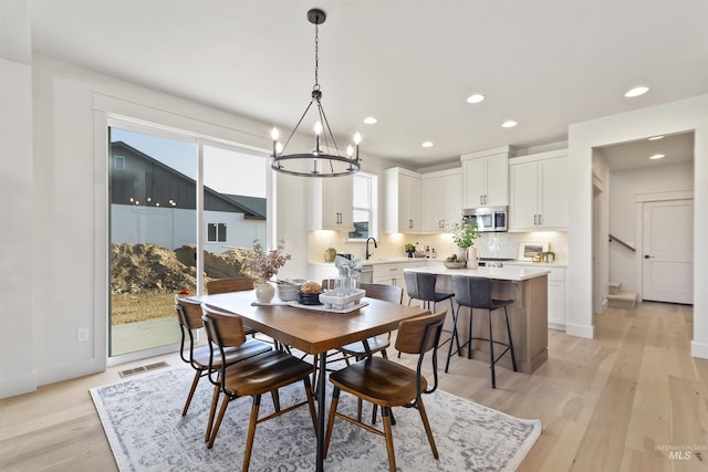 dining space with light wood-type flooring, baseboards, visible vents, and recessed lighting