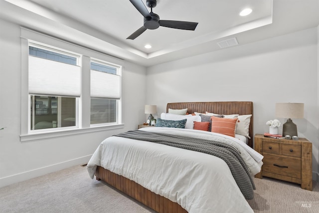 bedroom with baseboards, visible vents, a tray ceiling, and carpet flooring