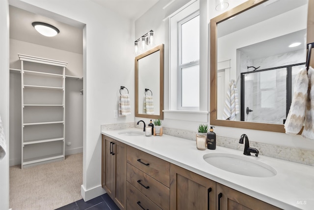 full bathroom featuring a stall shower, a sink, baseboards, and double vanity