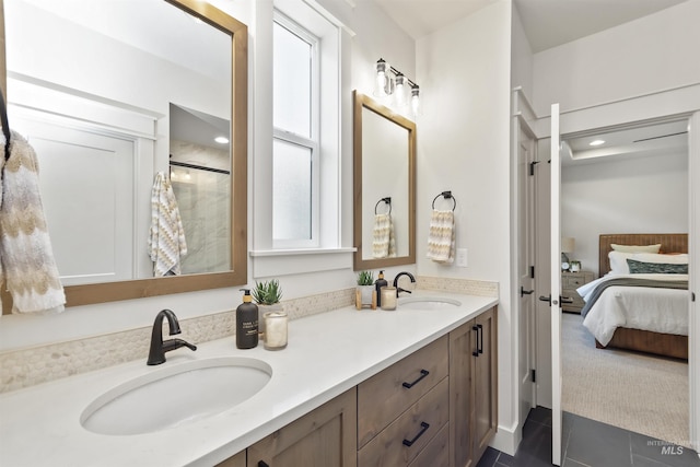 ensuite bathroom featuring tile patterned flooring, double vanity, a sink, and ensuite bathroom