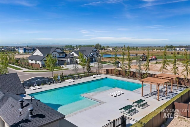 pool with a patio area and fence