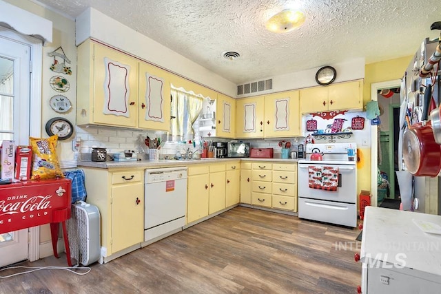 kitchen with backsplash, white appliances, dark hardwood / wood-style floors, and a textured ceiling