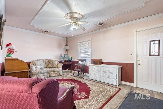 carpeted living room with crown molding and ceiling fan