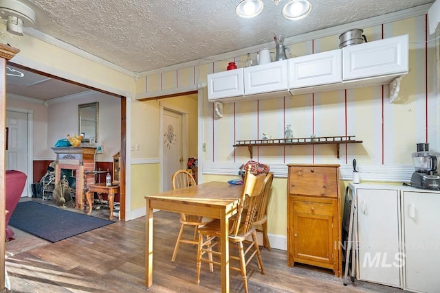 dining area with crown molding, a textured ceiling, and dark hardwood / wood-style flooring