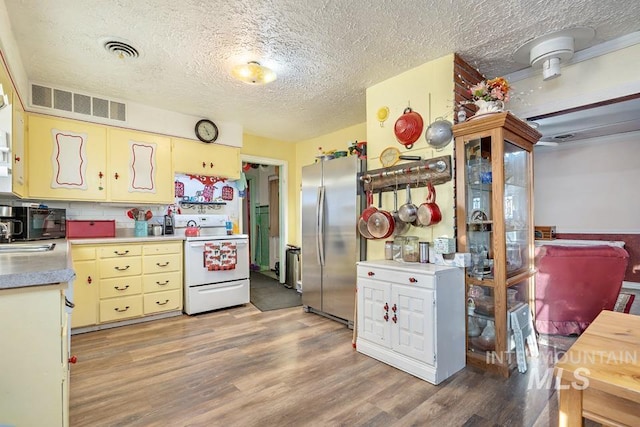 kitchen featuring stainless steel refrigerator, white electric stove, wood-type flooring, sink, and a textured ceiling