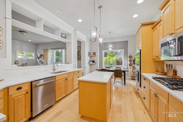 327 E Rockingham Dr, Eagle, ID 83616 - kitchen with appliances with stainless steel finishes, a sink, a kitchen island, light wood-style floors, and light countertops