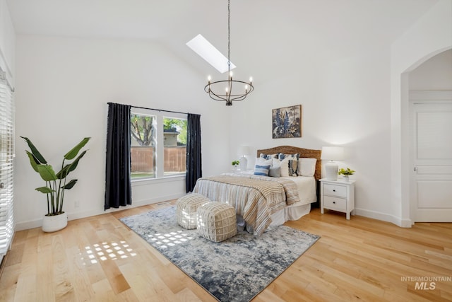 327 E Rockingham Dr, Eagle, ID 83616 - bedroom featuring a chandelier, arched walkways, a skylight, light wood-style floors, and high vaulted ceiling