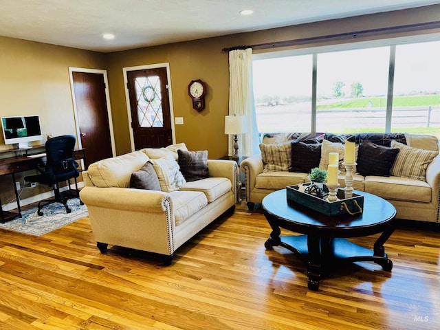 living room featuring light wood finished floors, recessed lighting, and a desk