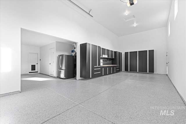 unfurnished living room featuring a high ceiling