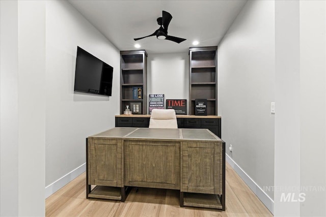 office featuring ceiling fan, light wood-type flooring, and built in features