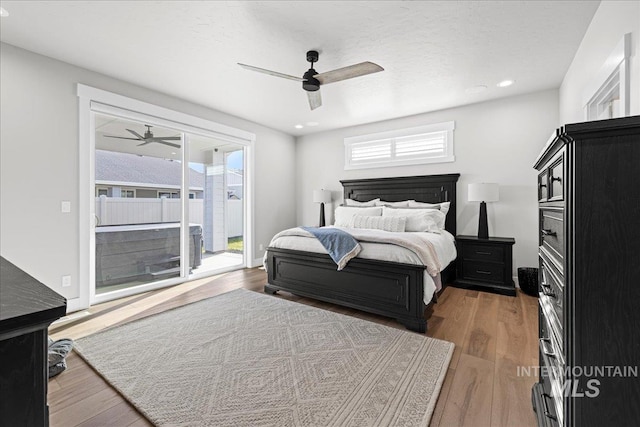 bedroom with dark wood-type flooring, ceiling fan, access to exterior, and multiple windows