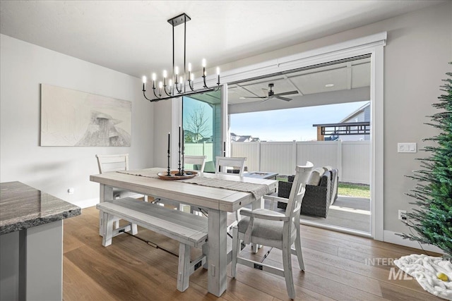 dining room featuring light hardwood / wood-style floors and ceiling fan with notable chandelier