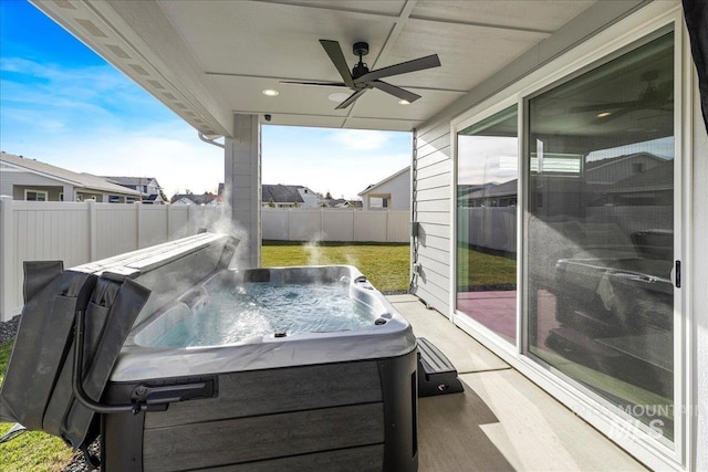 view of patio / terrace with ceiling fan and a hot tub