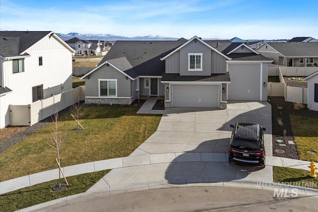 view of front of home featuring a front lawn, a garage, and a mountain view