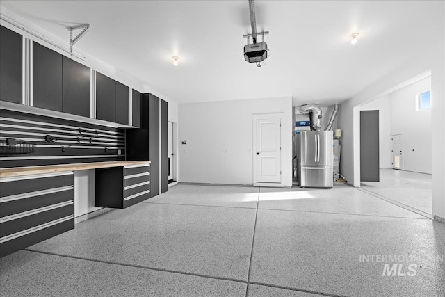 garage featuring stainless steel refrigerator and a garage door opener