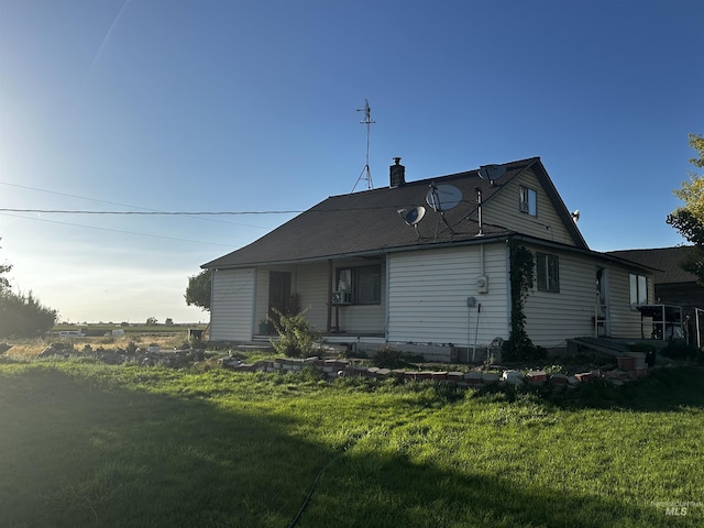 back of house with a lawn and a chimney