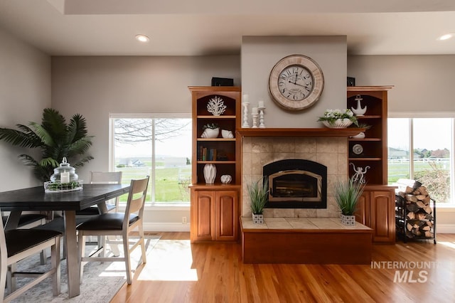 living area with recessed lighting, a fireplace, and light wood-style floors