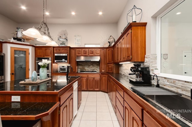 kitchen with light tile patterned floors, tasteful backsplash, appliances with stainless steel finishes, a sink, and under cabinet range hood