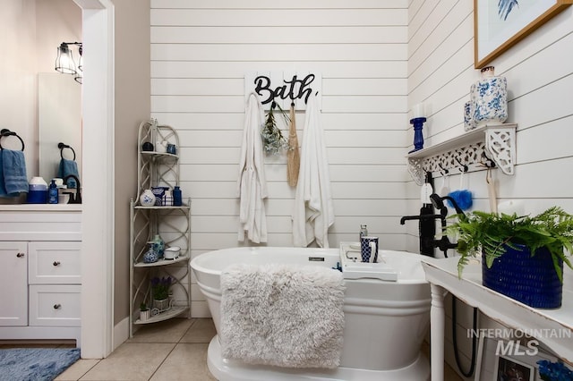 bathroom with a sink, a freestanding tub, and tile patterned floors