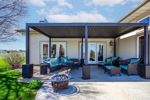 view of patio with an outdoor living space with a fire pit and french doors