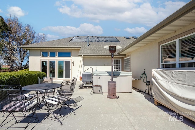 view of patio / terrace featuring a hot tub, central AC unit, and outdoor dining space