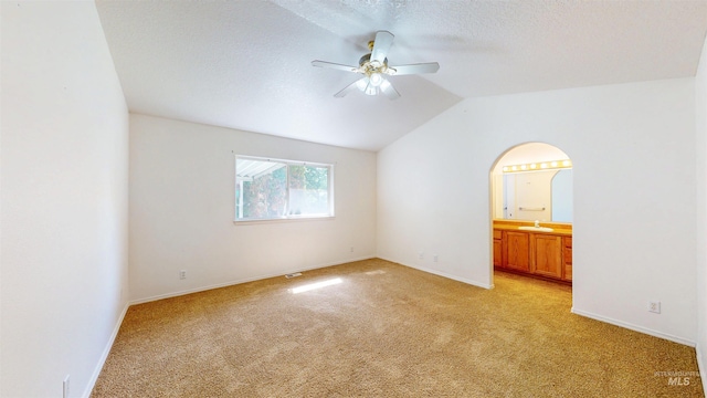 278 Trotter Dr, Twin Falls, ID 83301 - spare room featuring light carpet, ceiling fan, lofted ceiling, arched walkways, and a textured ceiling