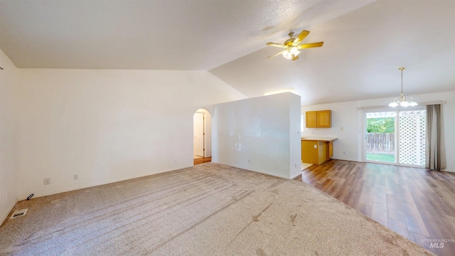 278 Trotter Dr, Twin Falls, ID 83301 - unfurnished living room featuring a ceiling fan, a chandelier, lofted ceiling, light carpet, and arched walkways
