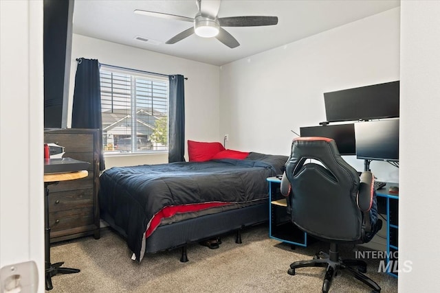 carpeted bedroom featuring an office area and a ceiling fan