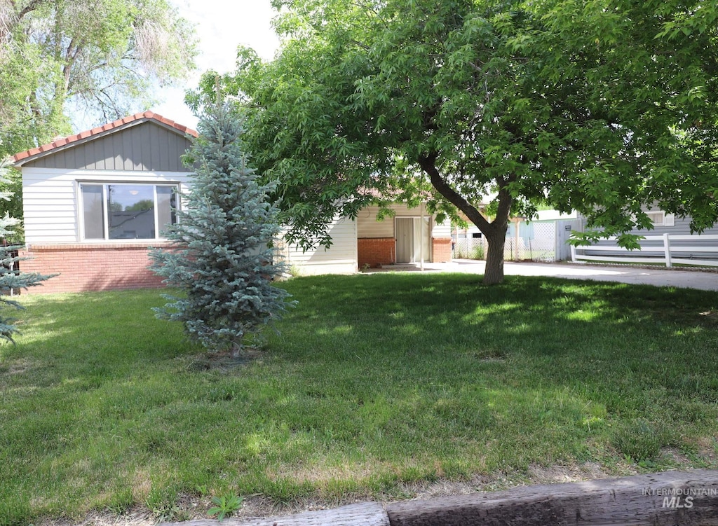 obstructed view of property featuring a front lawn