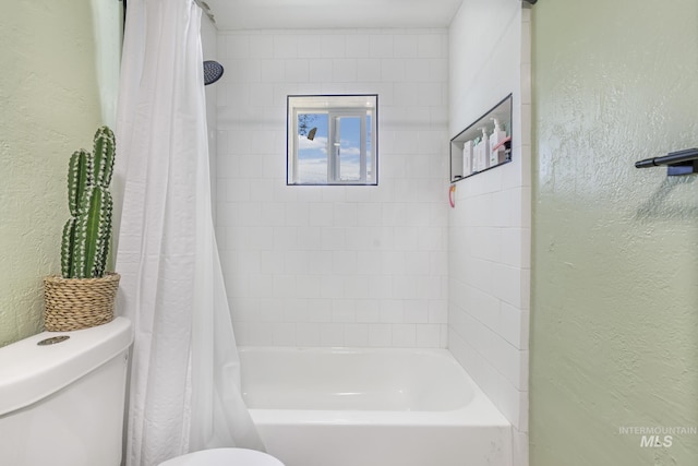 bathroom featuring a textured wall and toilet