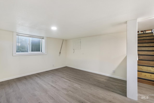 finished basement featuring baseboards, stairway, and wood finished floors