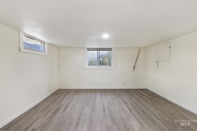 basement with baseboards and wood finished floors