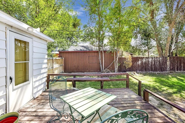 wooden terrace with a yard, outdoor dining space, and a fenced backyard