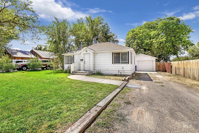 view of front of house featuring a garage, a front lawn, and an outdoor structure