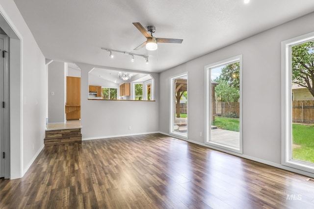 2943 S Zach Pl, Boise, ID 83706 - unfurnished living room featuring track lighting, dark wood finished floors, baseboards, a ceiling fan, and a chandelier
