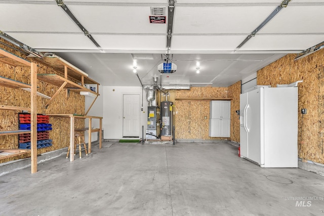 2943 S Zach Pl, Boise, ID 83706 - garage with white refrigerator with ice dispenser, gas water heater, and a garage door opener