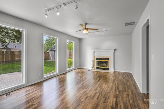 2943 S Zach Pl, Boise, ID 83706 - unfurnished living room with rail lighting, wood finished floors, a tiled fireplace, and ceiling fan