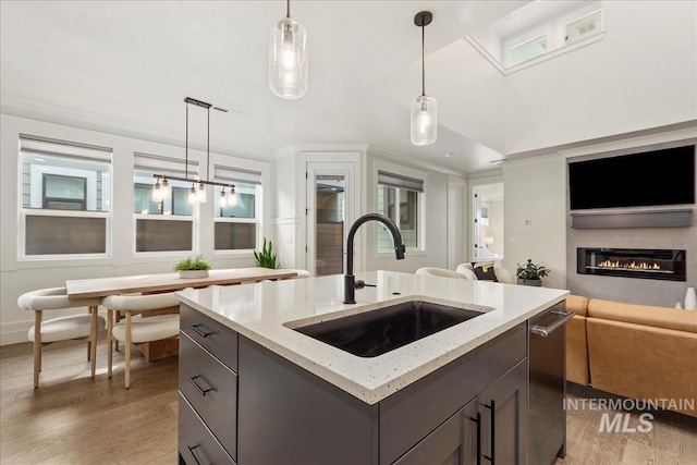 3268 S Sedgebrook Ln, Eagle, ID 83616 - kitchen with light stone countertops, a sink, open floor plan, a glass covered fireplace, and stainless steel dishwasher